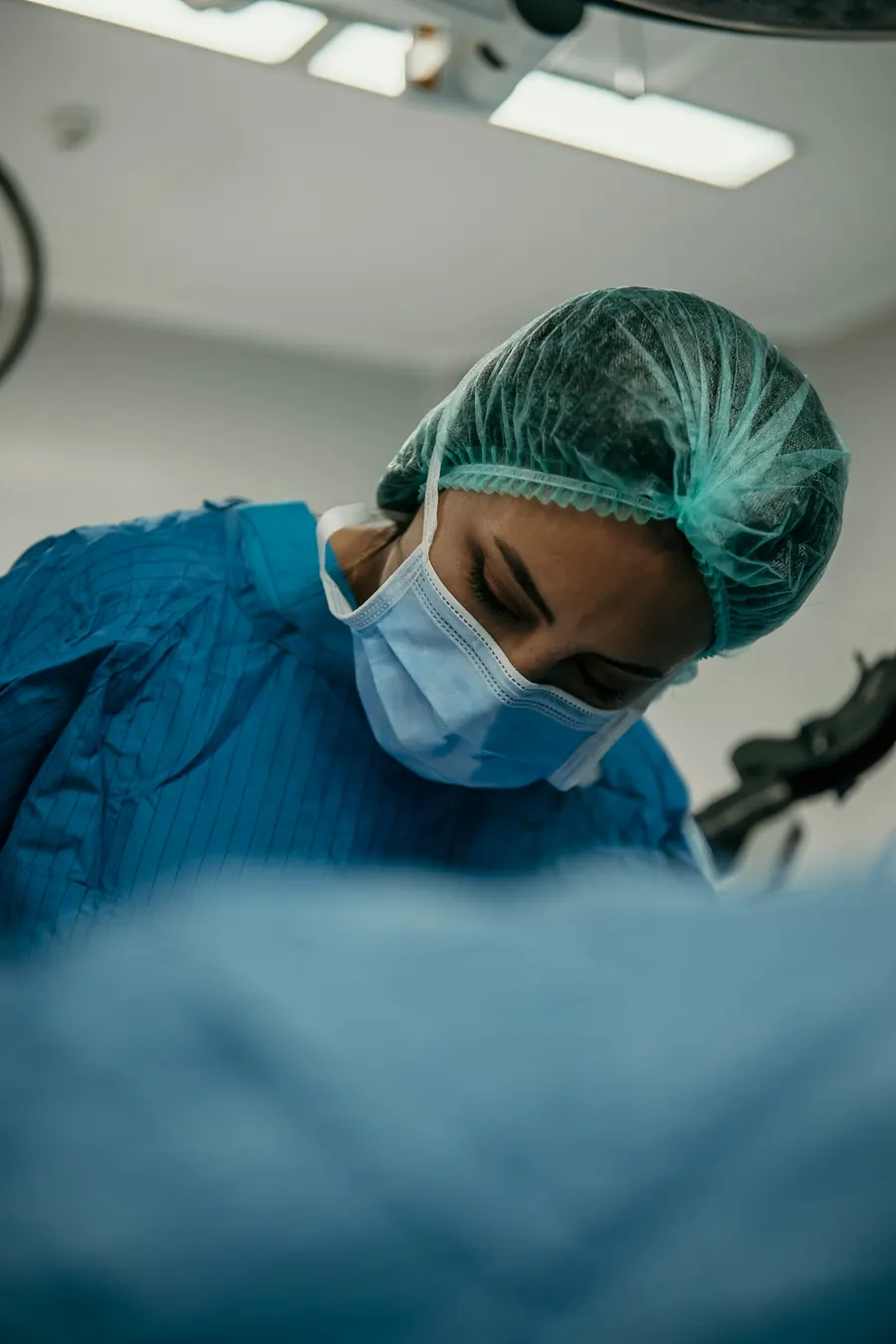 Chirurgienne concentrée pendant une opération, tenue de bloc