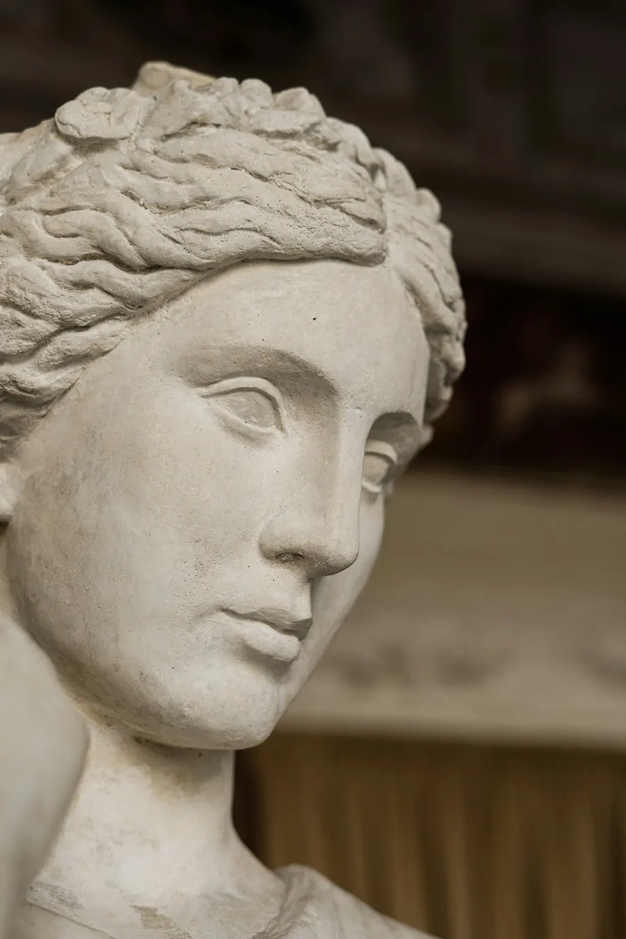 Profil d'un visage de sculpture en marbre, lumière rasante, fond neutre