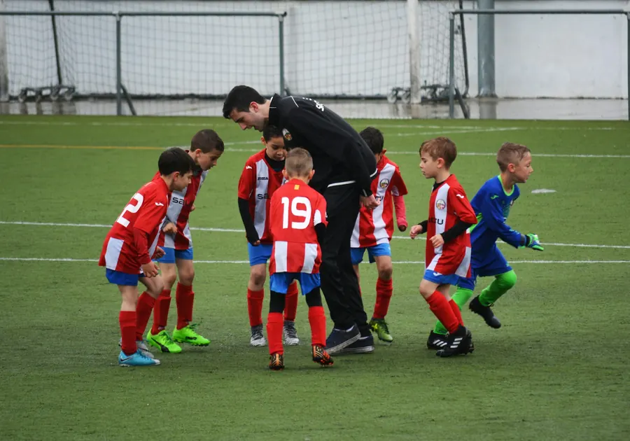 Éducateur qui explique un exercice à des enfants de 12 ans