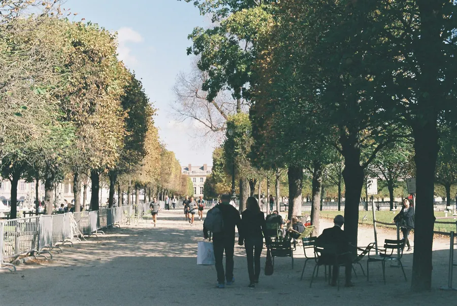 Deux personnes qui marchent en parlant dans un jardin parisien