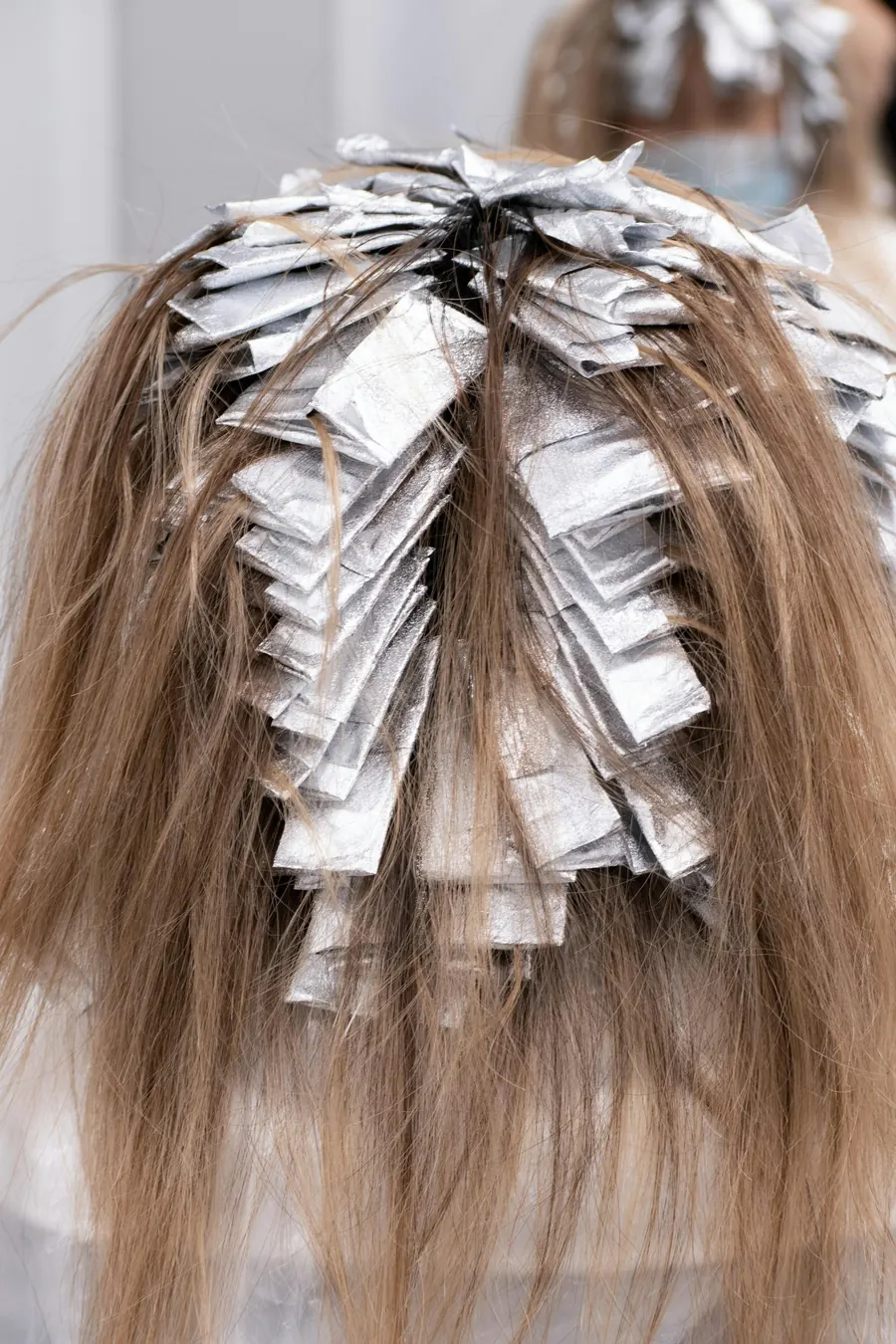 Mèches de cheveux enveloppées dans du papier aluminium pour une coloration
