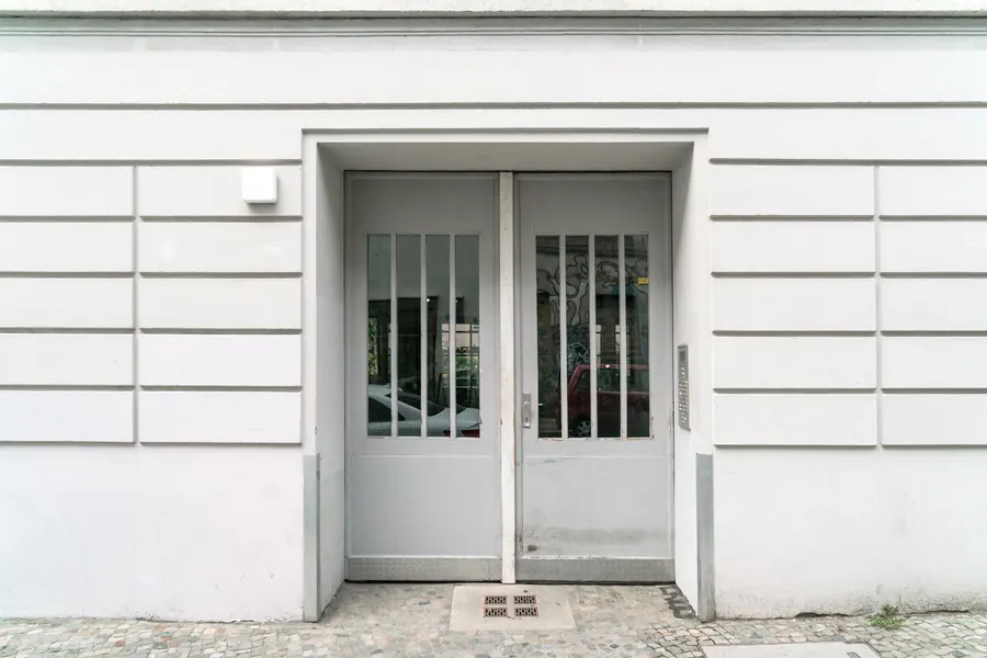 Entrée d'une étude en rez-de-chaussée, porte vitrée, plaque discrète