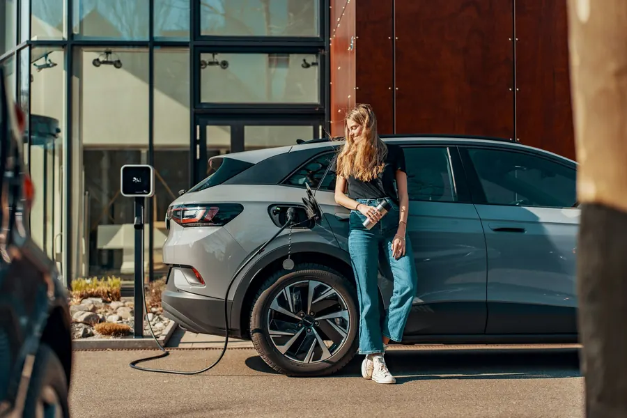 Voiture électrique compacte en charge sur une borne devant la concession