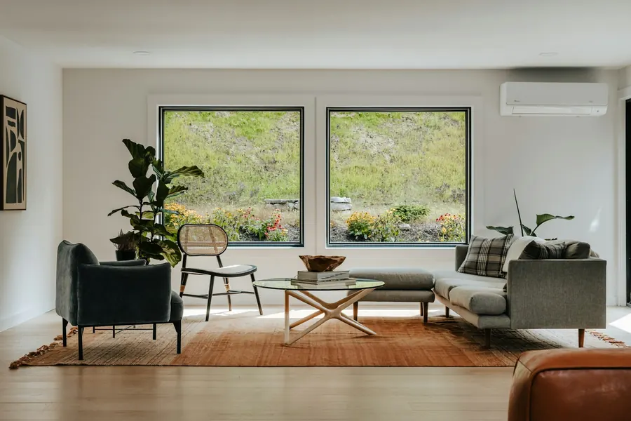 Séjour traversant d'une maison neuve, grandes baies, lumière naturelle, peu de mobilier