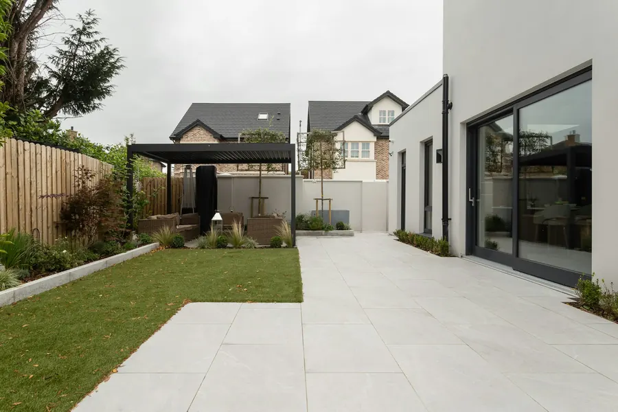 Maison moderne avec cour pavée et petit toit plat, enduit clair