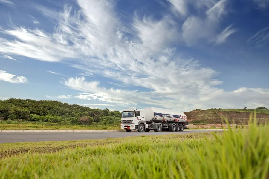 Camion-citerne blanc qui roule sur une route de campagne