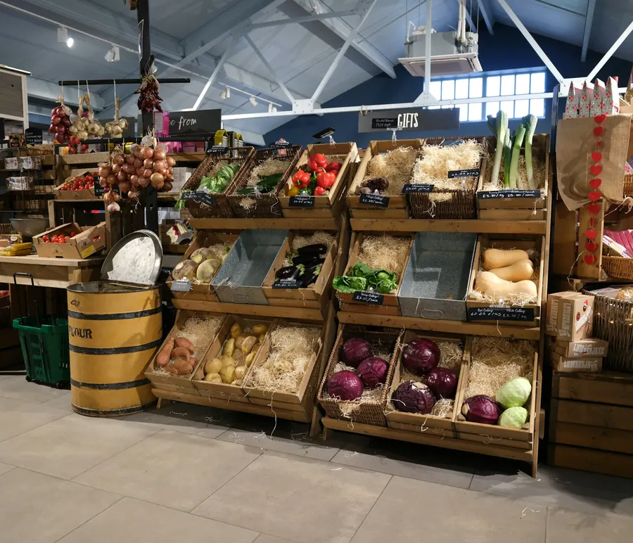 Étals de légumes dans des cagettes en bois, sans client visible