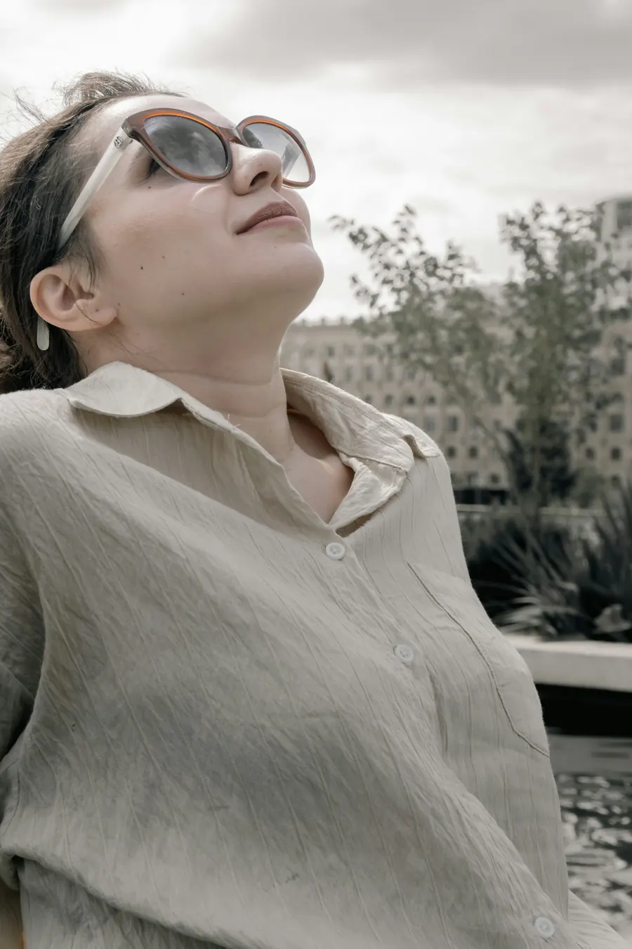 Chemise ample en lin lavé portée, lumière naturelle, fond mur de pierre