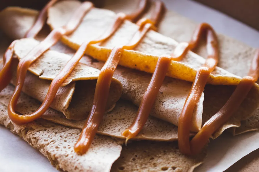Crêpe pliée nappée de caramel au beurre salé, assiette en faïence