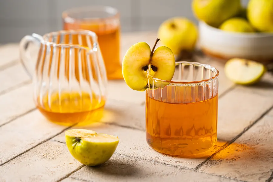 Bolées de cidre et pichet en grès sur une table en bois