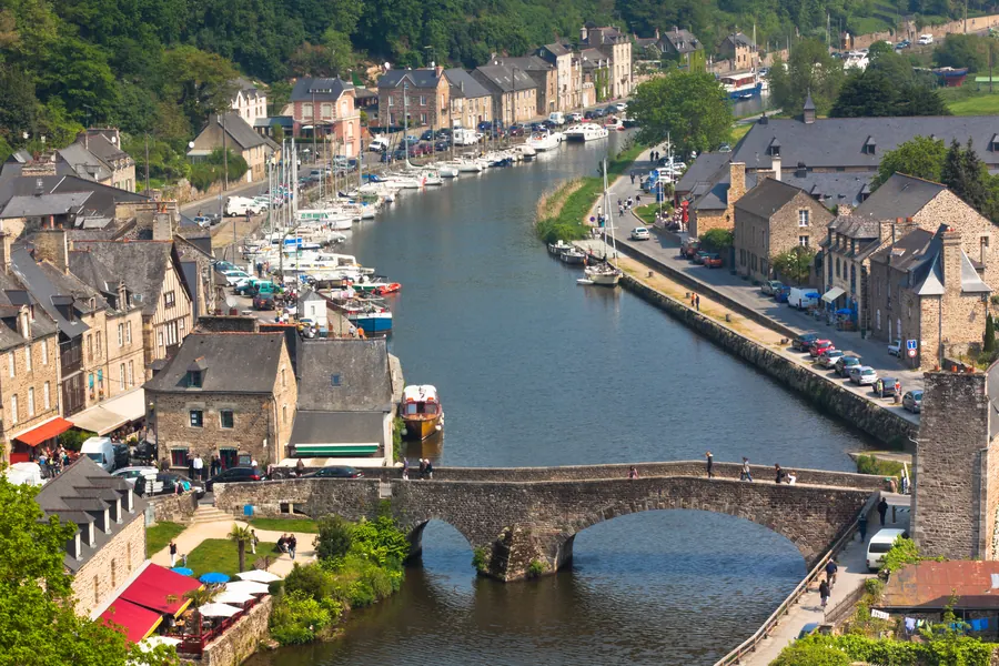 Le port de Dinan au bord de la Rance, vieux pont de pierre, bateaux à quai
