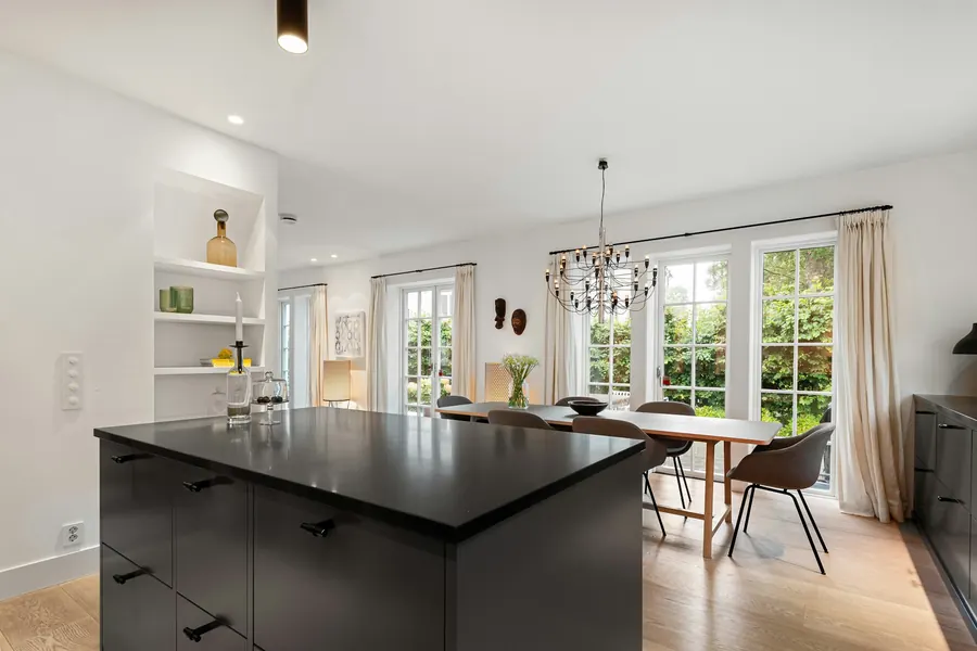 Îlot en quartz blanc, façades noir mat, suspensions en laiton