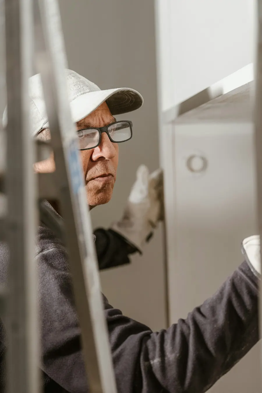 Homme qui règle une porte de meuble de cuisine, regard concentré