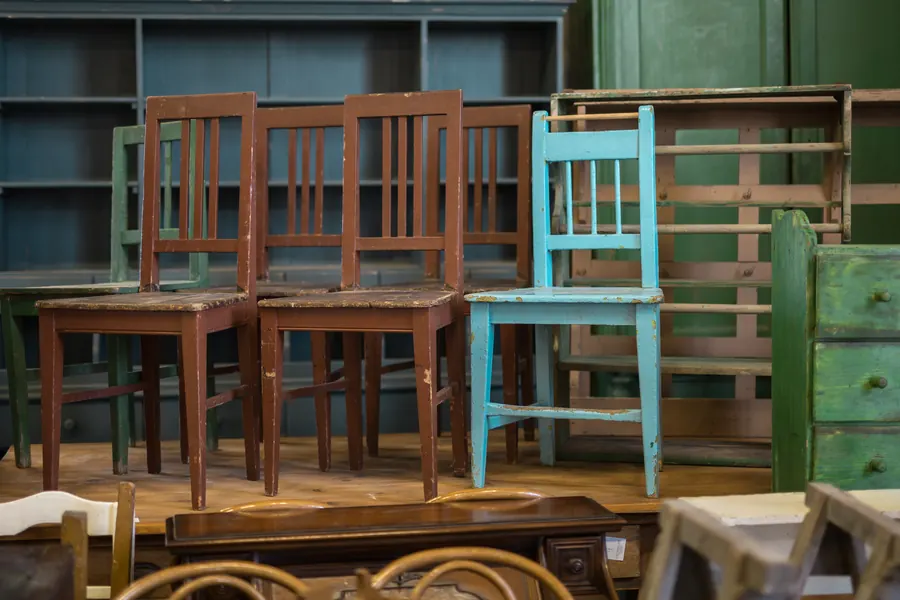 Dépôt de meubles d'occasion, chaises et armoires en bois, lumière douce