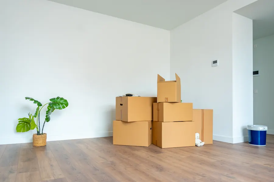 Cartons étiquetés par pièce empilés dans un salon vide