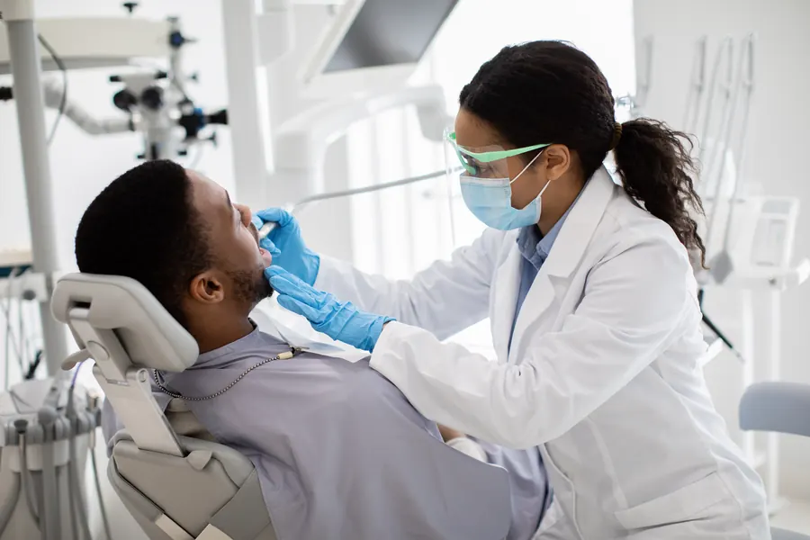 Un patient examiné par une professionnelle de santé dentaire