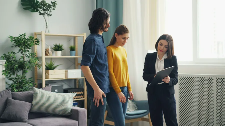 Une professionnelle échange avec un couple dans son salon