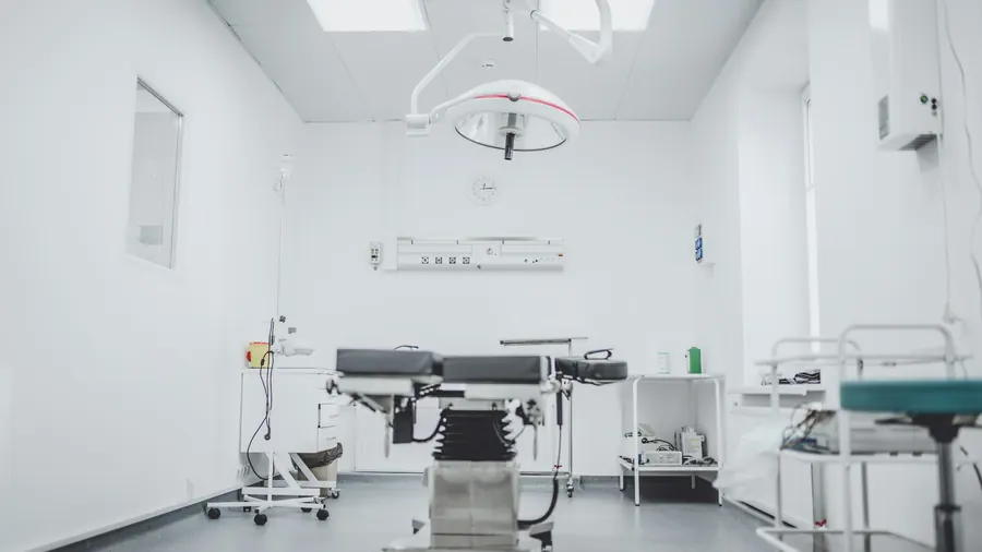 Petite salle d'intervention, table, éclairage opératoire, instruments rangés, sans patient