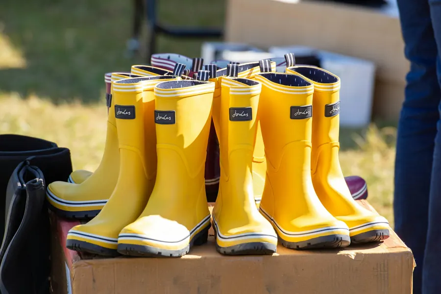 Bottes de pluie jaunes alignées en rangée sur une caisse