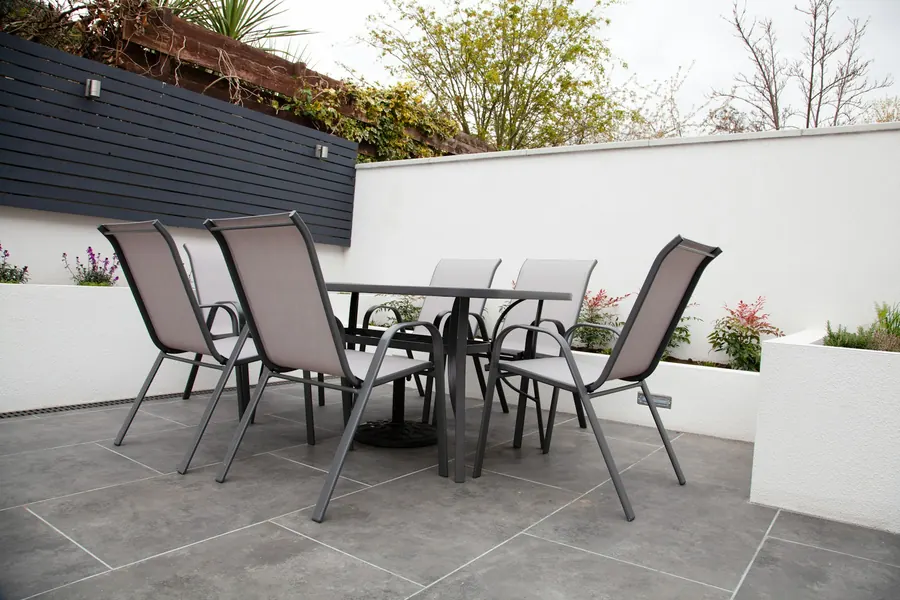 Salon de jardin gris avec table et chaises sur une terrasse