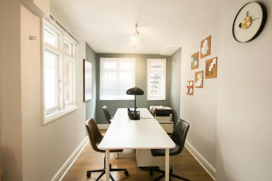 Petit cabinet lumineux, bureau et deux fauteuils, plantes, aucun matériel médical en évidence
