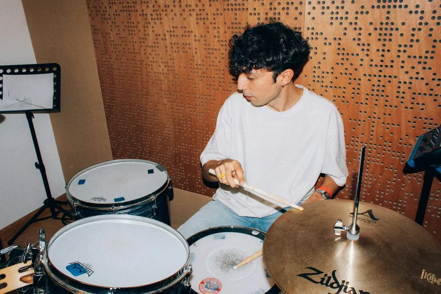 Adolescent qui joue de la batterie en studio, sans professeur