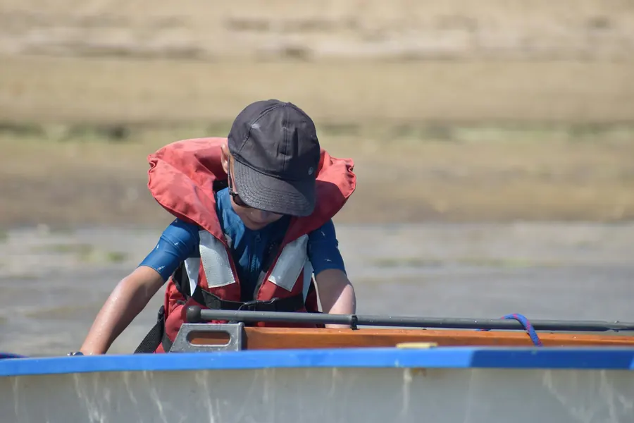 Enfant concentré à la barre de son optimist