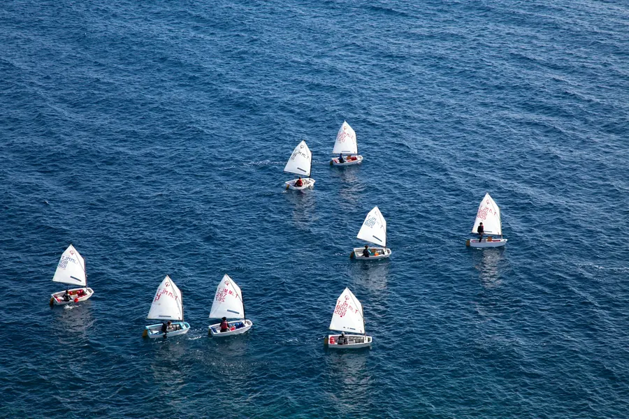 Petits voiliers d'apprentissage alignés sur une mer calme