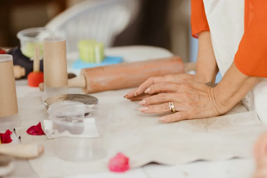 Mains qui pétrissent de la pâte sur une table
