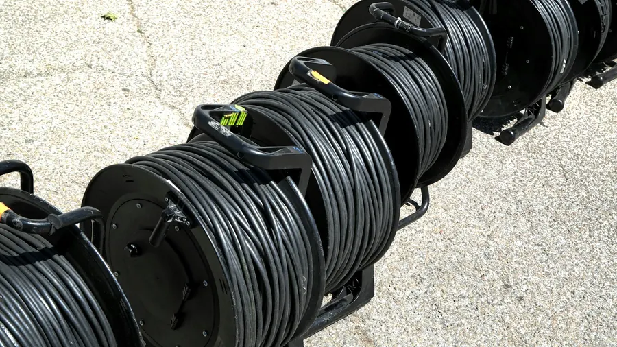 Étagère de grandes bobines de câble noir dans un entrepôt