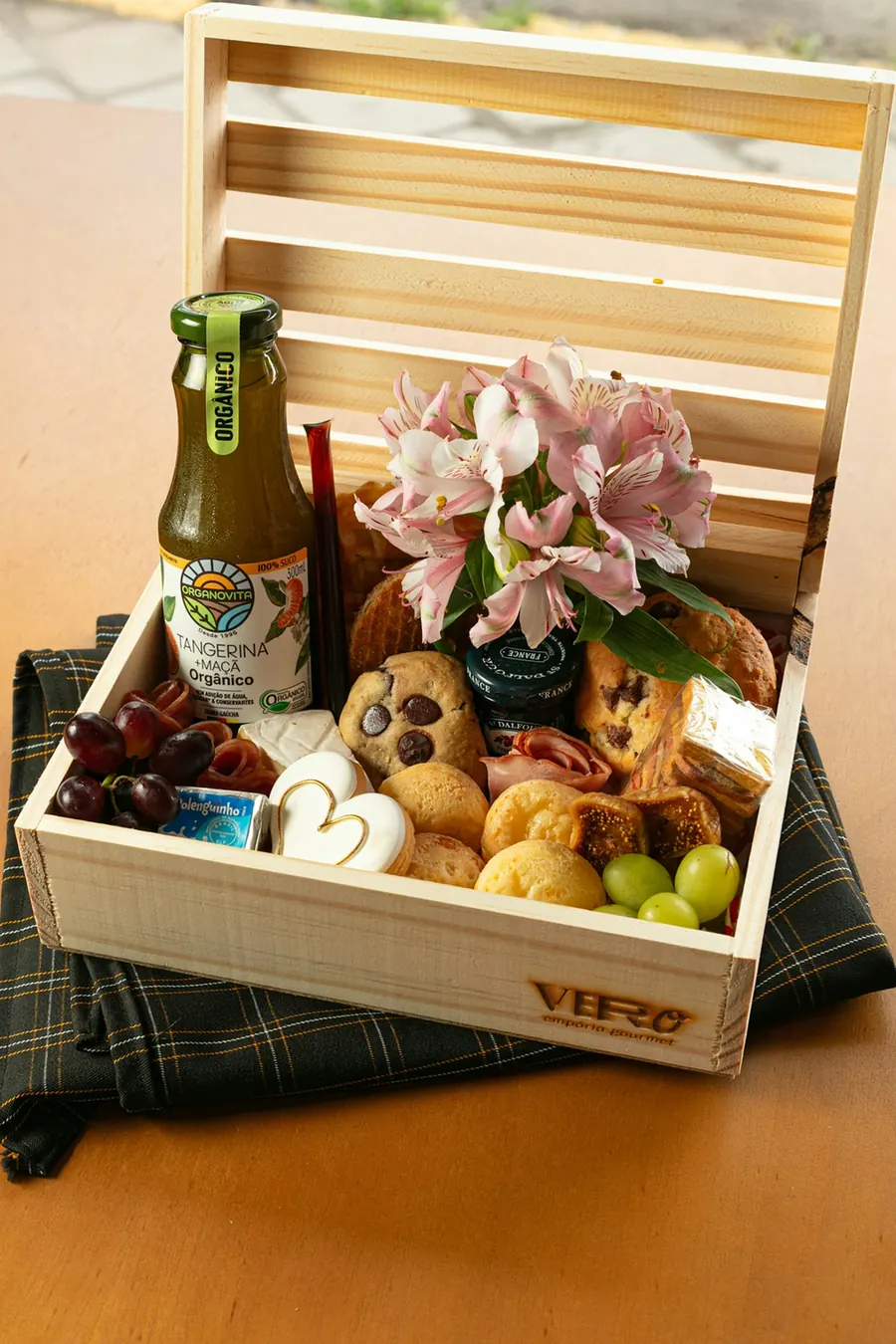 Caisse en bois garnie de vin, fruits, pain et fleurs