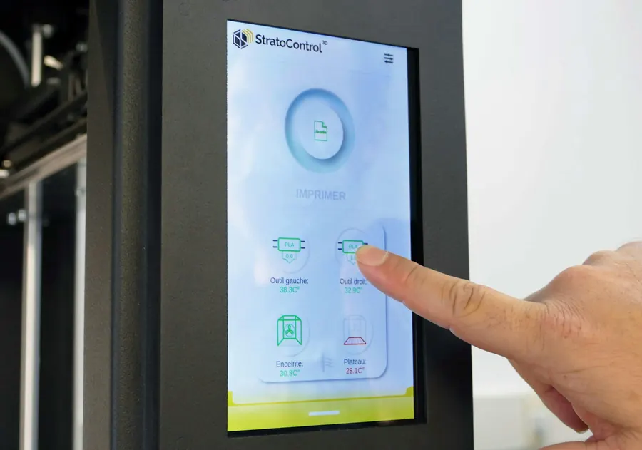 Doigt qui appuie sur l'écran tactile d'un panneau de contrôle industriel