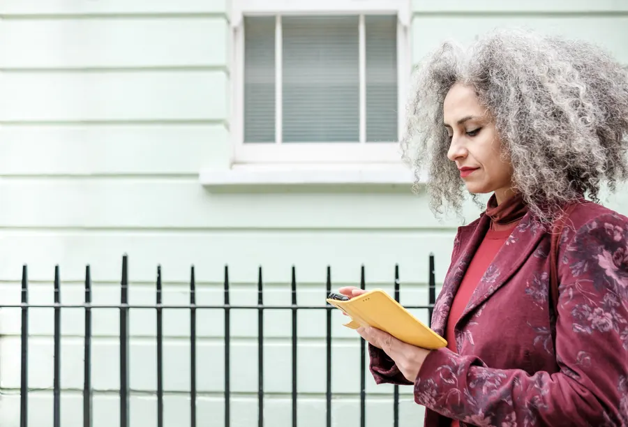 Experte devant une maison ancienne, carnet en main, lumière d'automne