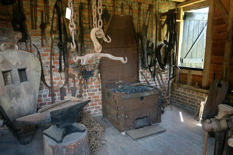 Intérieur de forge : outils suspendus, enclume, lumière de fenêtre