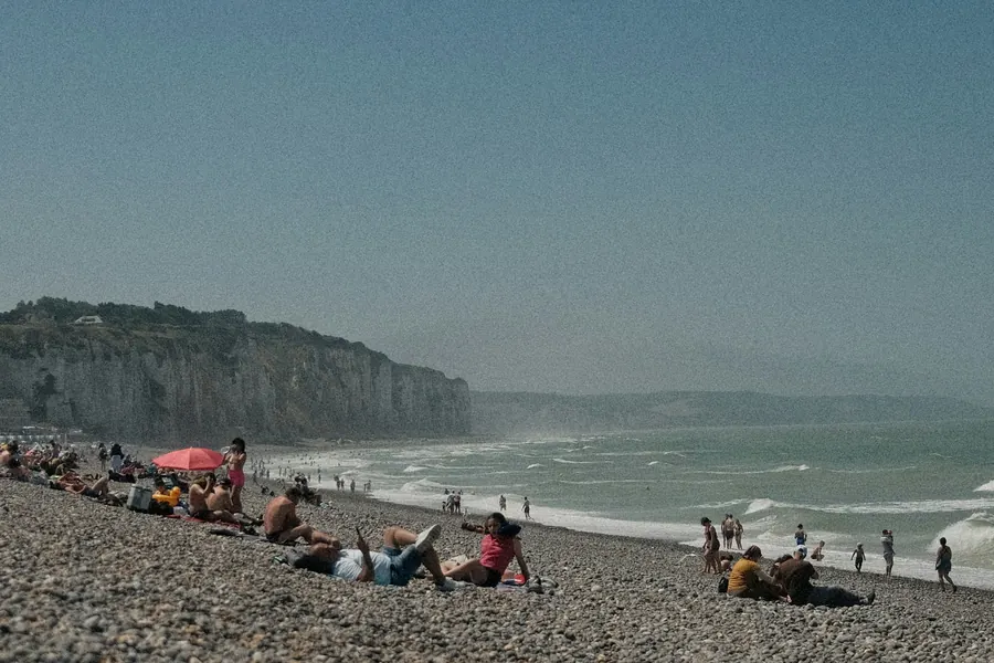 Groupe de personnes qui se détendent sur une plage de galets