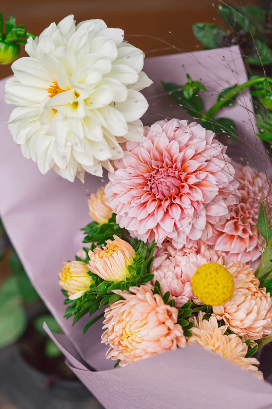 Bouquet de dahlias et cosmos dans du papier kraft