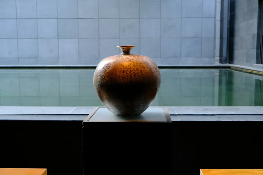 Vase en céramique brun sur un présentoir sombre