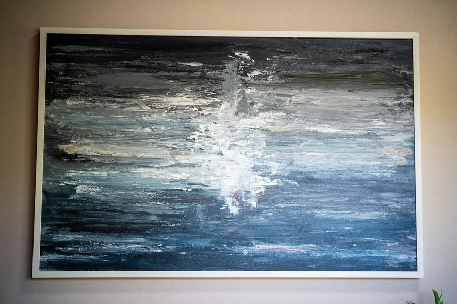 Peinture abstraite grise et blanche accrochée seule au mur