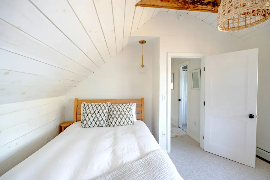 Chambre sous les poutres, linge blanc, fenêtre sur le jardin