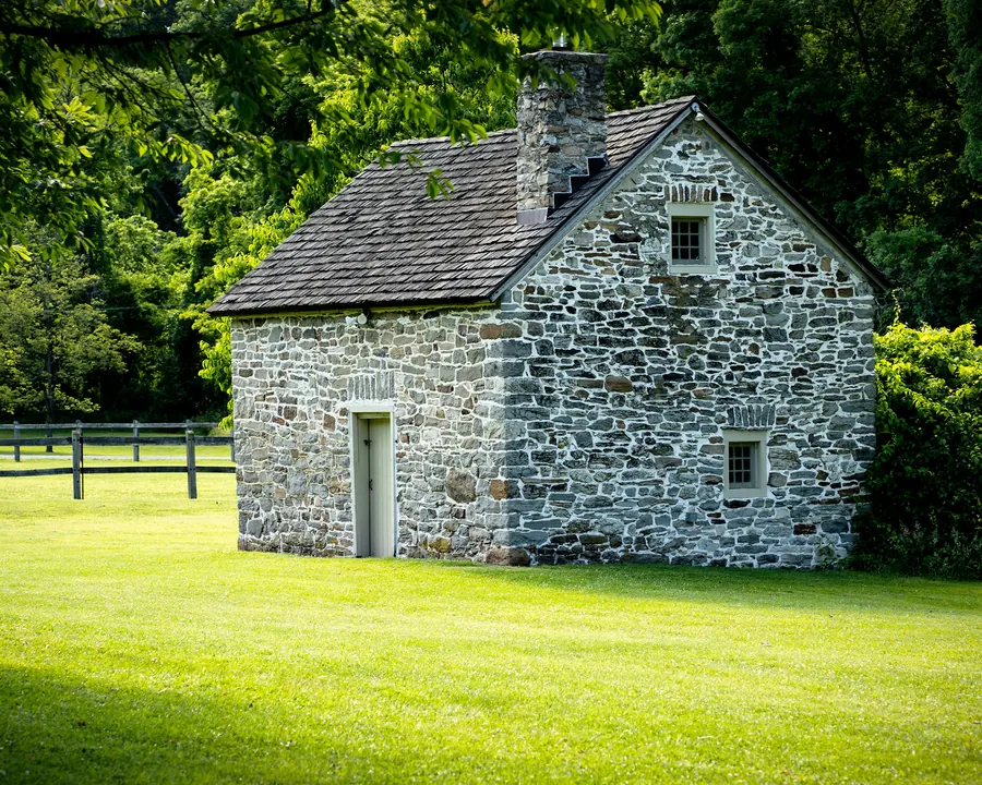 Maison en pierre grise avec un grand jardin