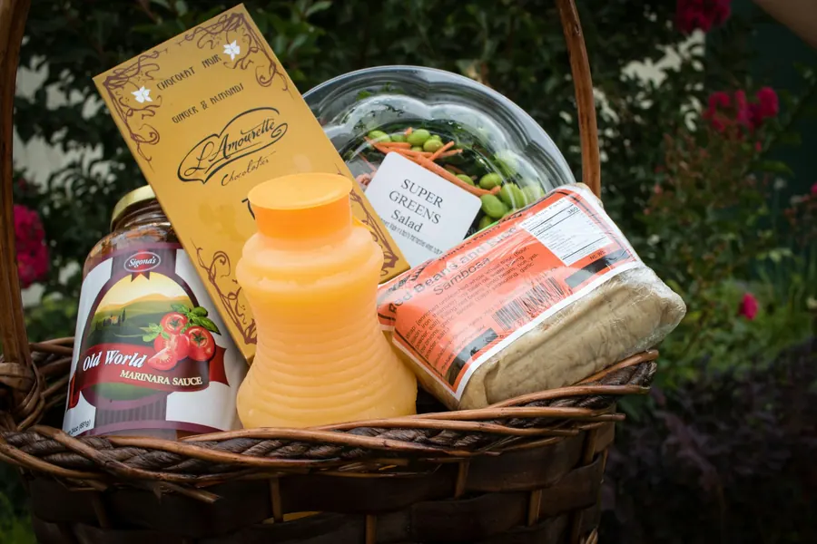 Panier garni de bouteille et petits pots, dans un jardin