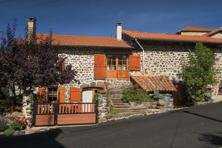 Maison de pierre aux volets rouges, jardin et table extérieure