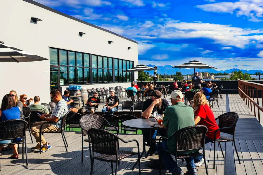 Terrasse de club-house avec tables au déjeuner, vue sur le dernier green