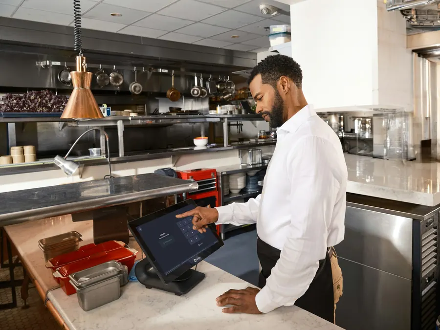 Restaurateur qui passe commande sur une tablette dans sa cuisine après le service