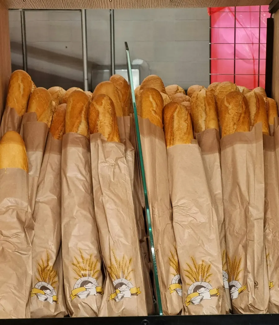 Sachets à pain en kraft empilés sur un comptoir de boulangerie