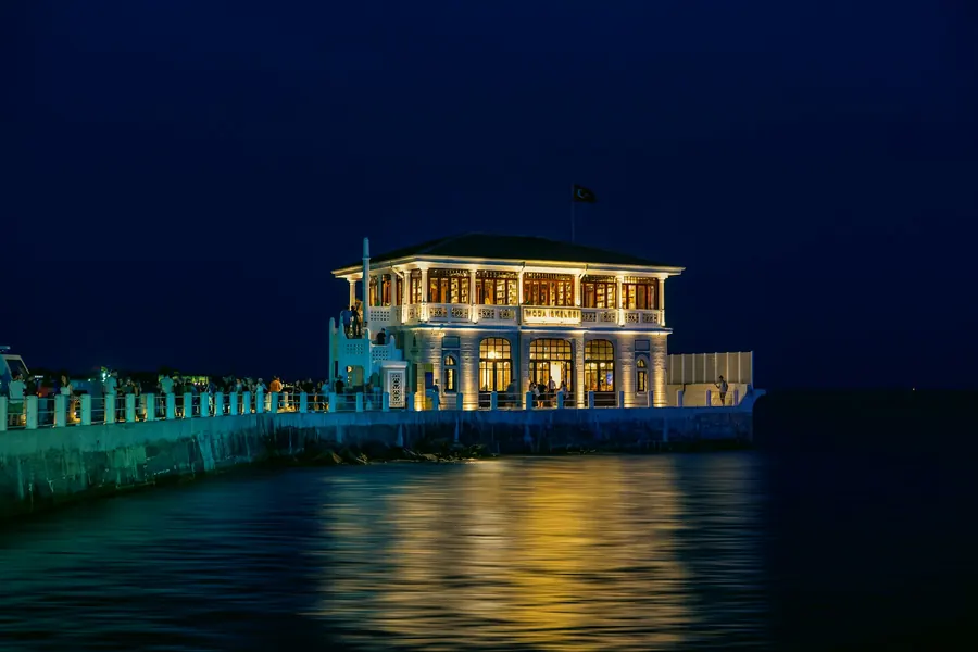 Pavillon élégant illuminé au bord de l'eau à l'heure bleue