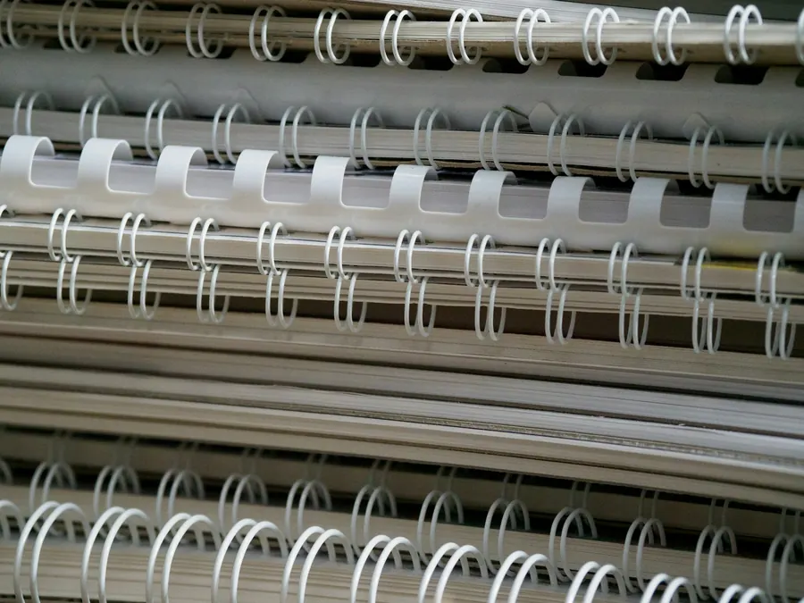 Gros plan de reliures à spirale métallique sur une pile de documents