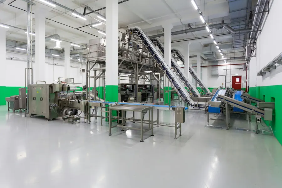Ligne de conditionnement de produits laitiers en fonctionnement, convoyeurs inox, aucune marque lisible