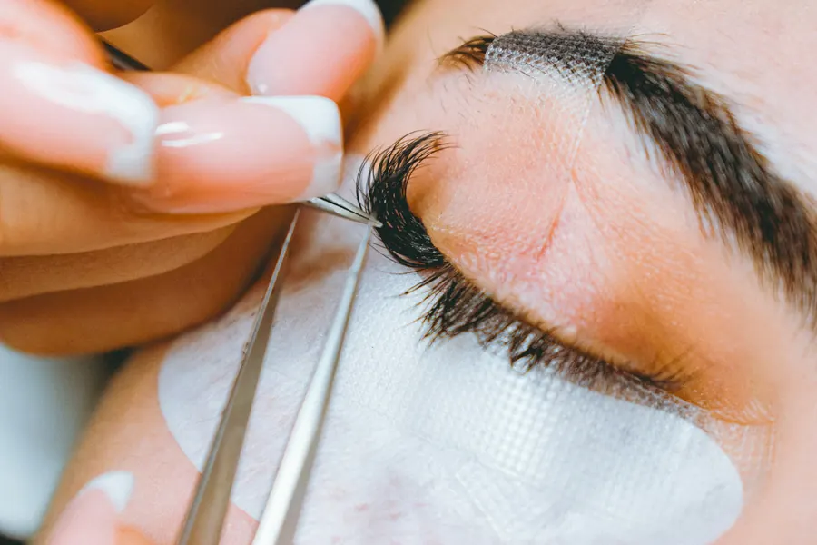 Rehaussement de cils en cours, gros plan sur les gestes