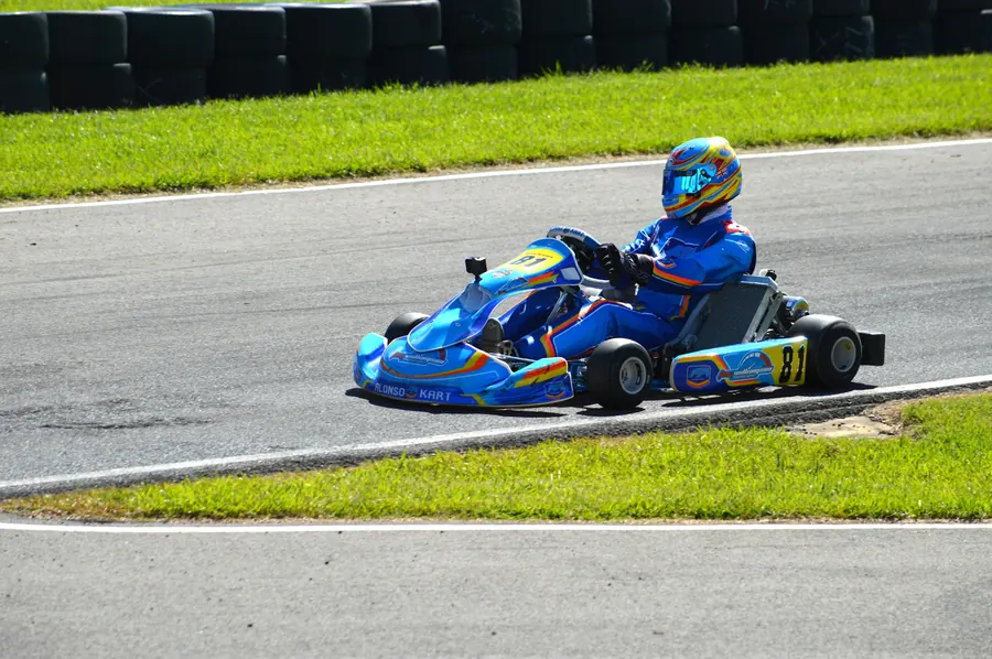 Kart lancé dans un virage sur une piste extérieure bordée d'herbe